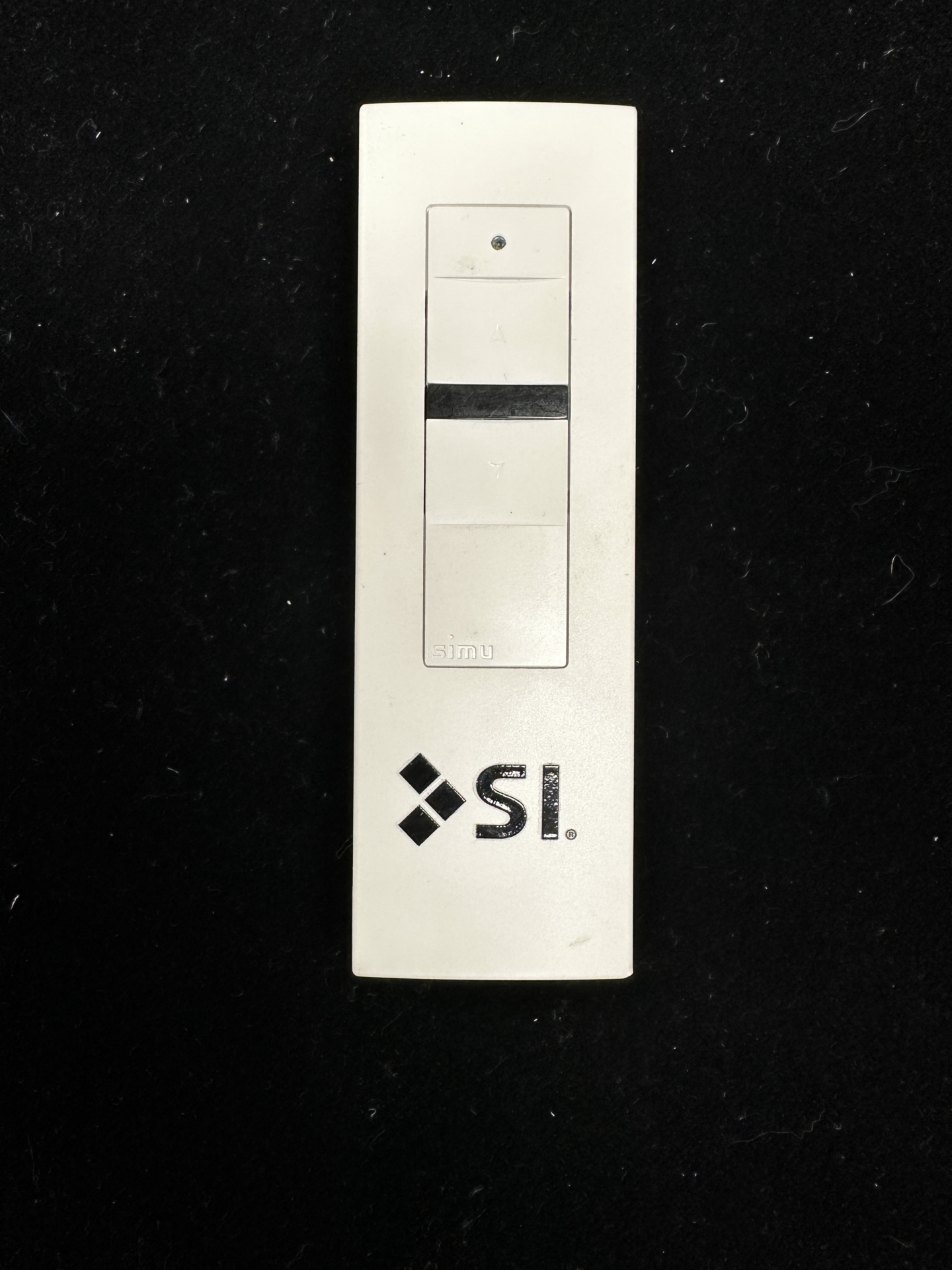 White Simu remote with black Stop button, used to identify Somfy motor type