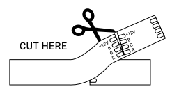 Scissors cutting LED strip wire at marked cut point on frame section