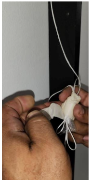 Hands gathering and bundling white tension cords from spring cassette before installation