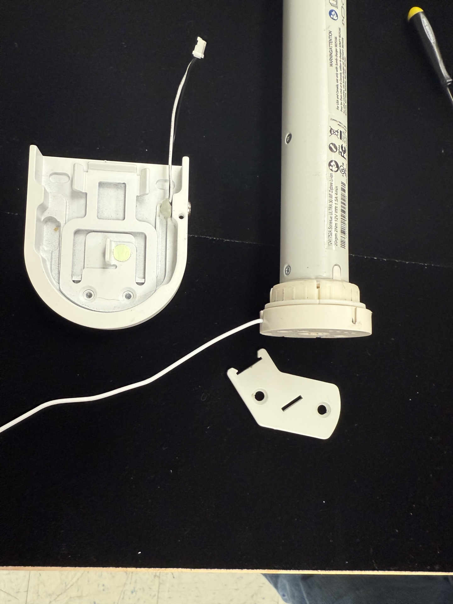 Tombstone end cap, motor tube, and bracket clip separated showing internal charging magnet assembly components