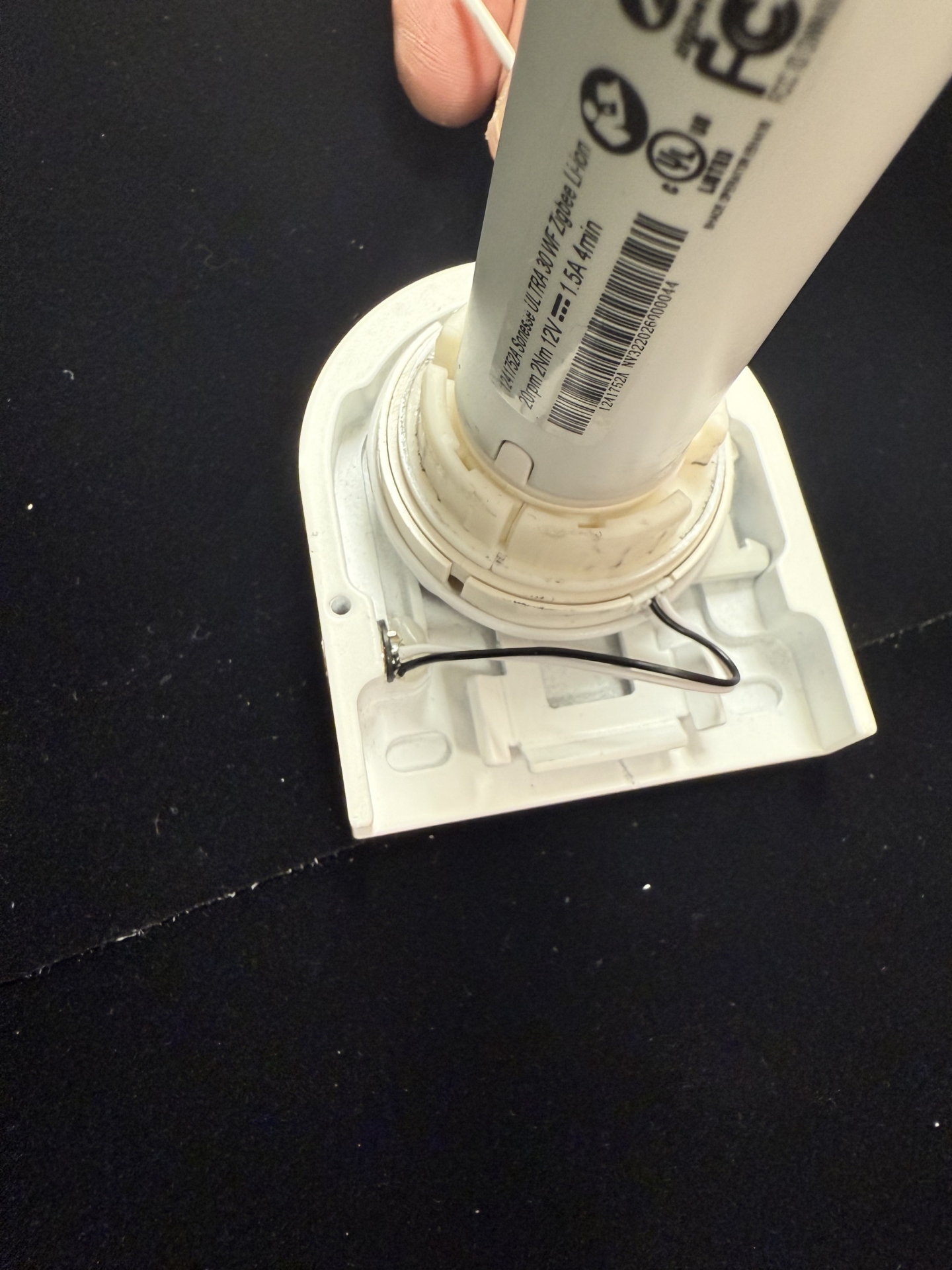 Tombstone end cap with antenna wire visible inside, being inserted onto motor tube