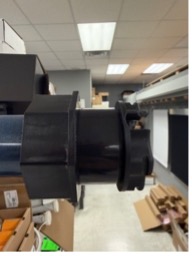 KAOS shade roll mounted between two brackets showing motor and idler plate attachment points