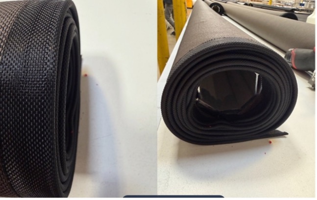 Black projection screen fabric tightly rolled, shown from two angles on a work surface